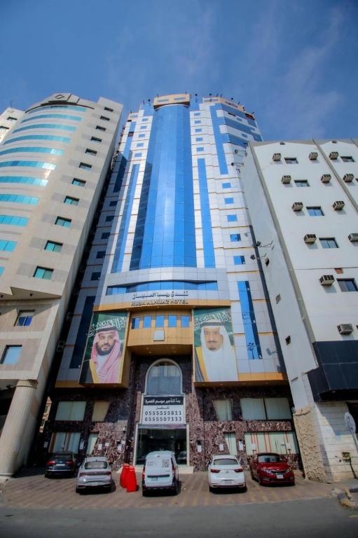 a tall building with cars parked in front of it at فندق ربا الحجاز توصيل للحرم in Az Zahrāʼ