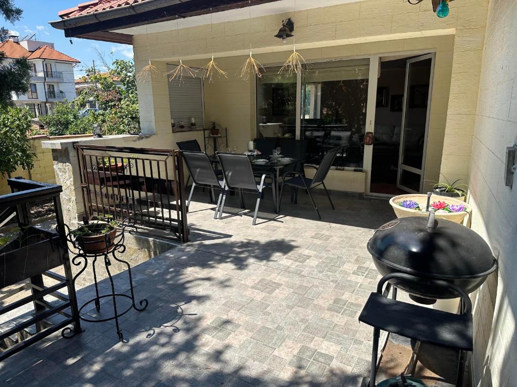 a patio with a grill and a table and chairs at Къща за гости Амбър in Burgas