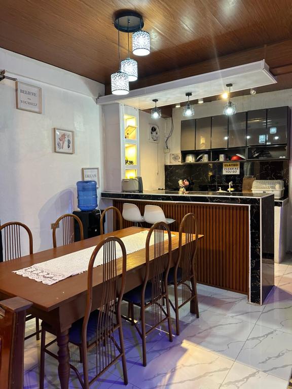 a dining room with a wooden table and chairs at LALEAH Transient House in Cotabato