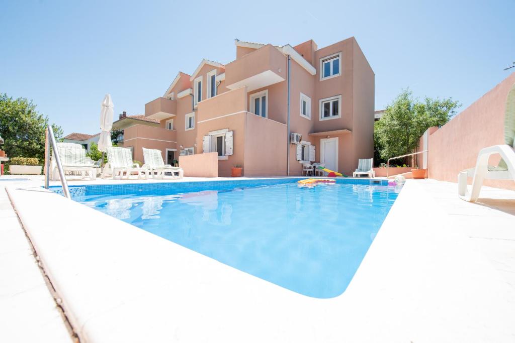 a swimming pool in front of a villa at Villa Best Relax in Okrug Donji