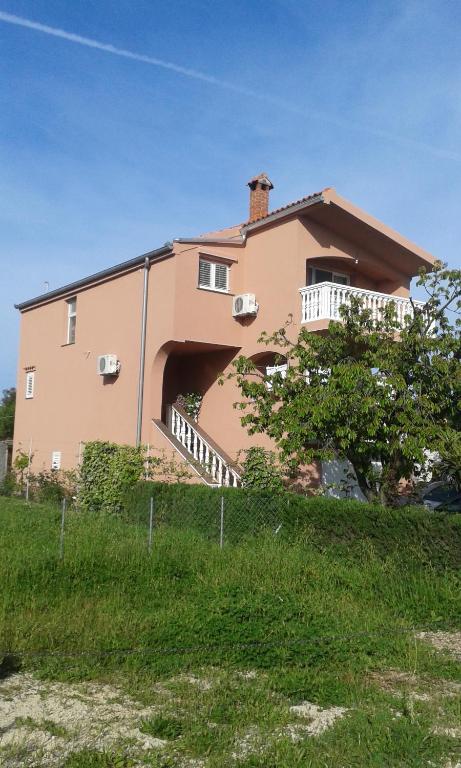 dom na wzgórzu z płotem przed nim w obiekcie Apartmani Vilma w Bibinje