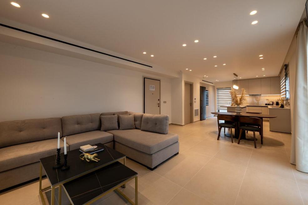 a living room with a couch and a table at ΛΑΚΩΝΙΖΕΙΝ Luxury Suites in Sparta