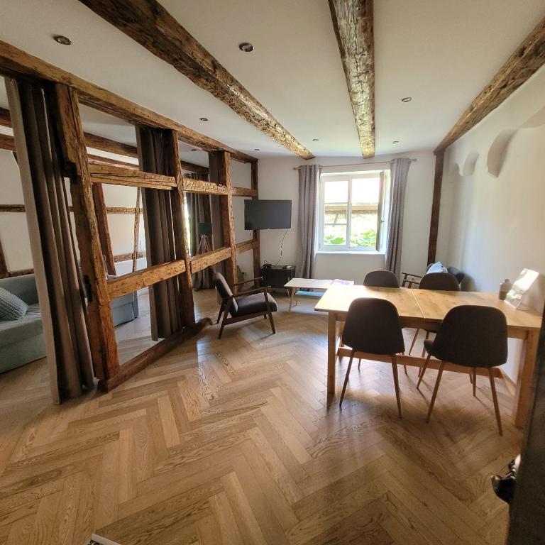 a dining room with a table and chairs in a room at Le FENUA in Colmar