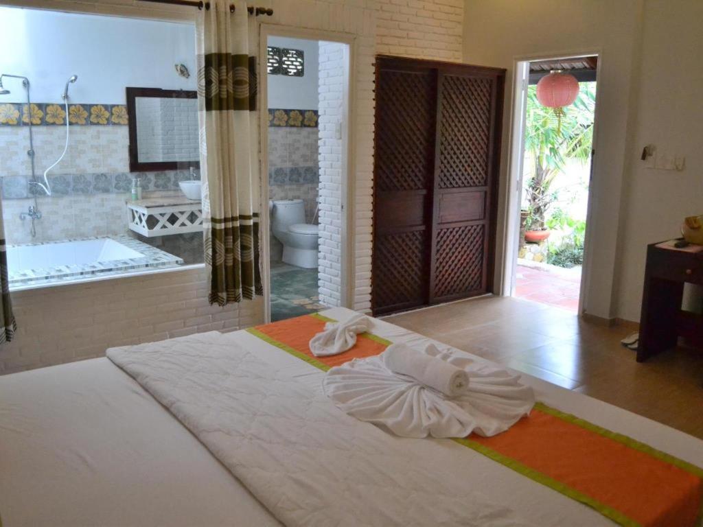1 dormitorio con baño con bañera y 1 cama en Green Hill Resort and Spa, en Mui Ne