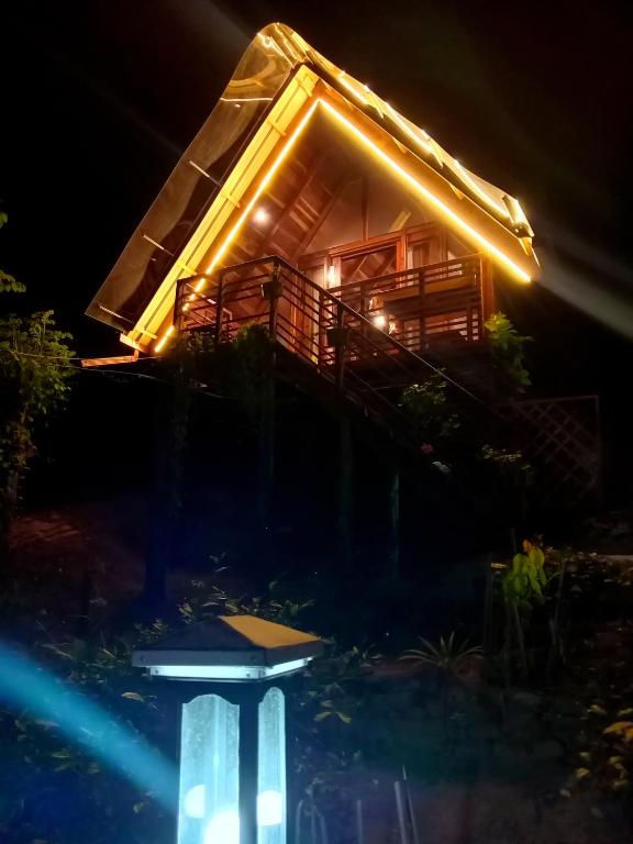 a tree house at night with a table in the foreground at Glenora Wood Cabin in Ella