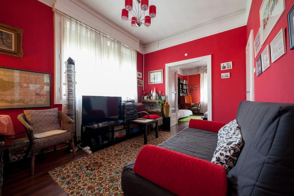 a red living room with a couch and a tv at Lonyay Street Apartment in Budapest