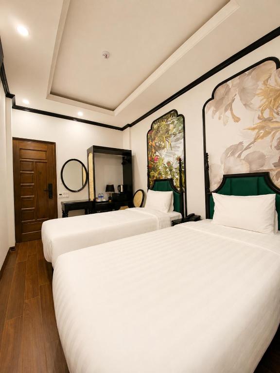 two beds in a hotel room with white sheets at Hanoi Silk Crown Boutique Hotel & Spa in Hanoi