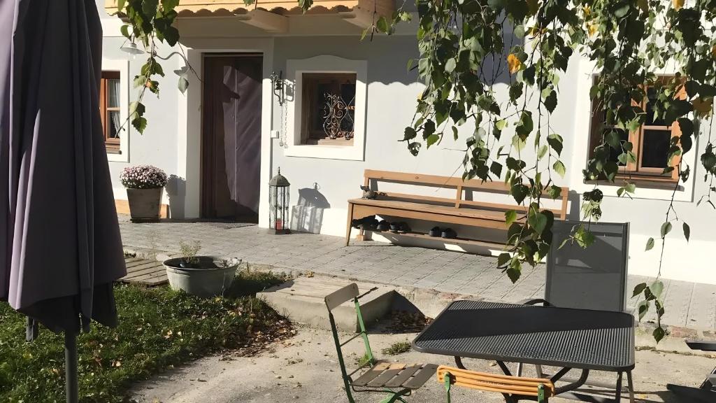 a bench sitting outside of a house with a porch at Unter der Linde in Tittmoning