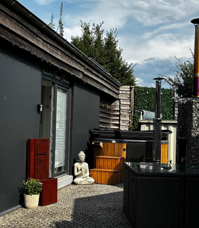 a statue of a buddha sitting on a patio at Relax Trois Bornes - De Grenspost in Gemmenich