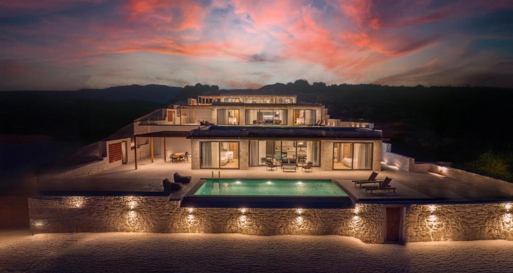 a large house with a swimming pool in front of it at Infinity View Luxury Villas in Galiá