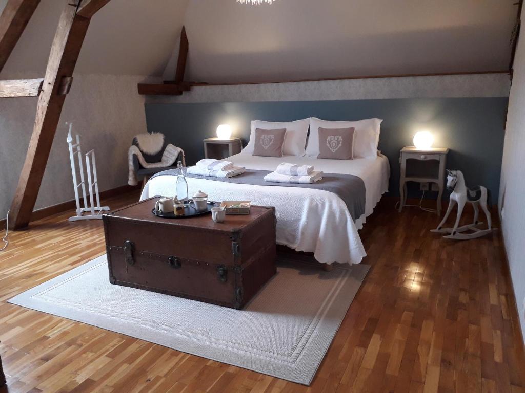 a bedroom with a large bed with a wooden floor at Chez Mathilde in Eaux-Puiseaux