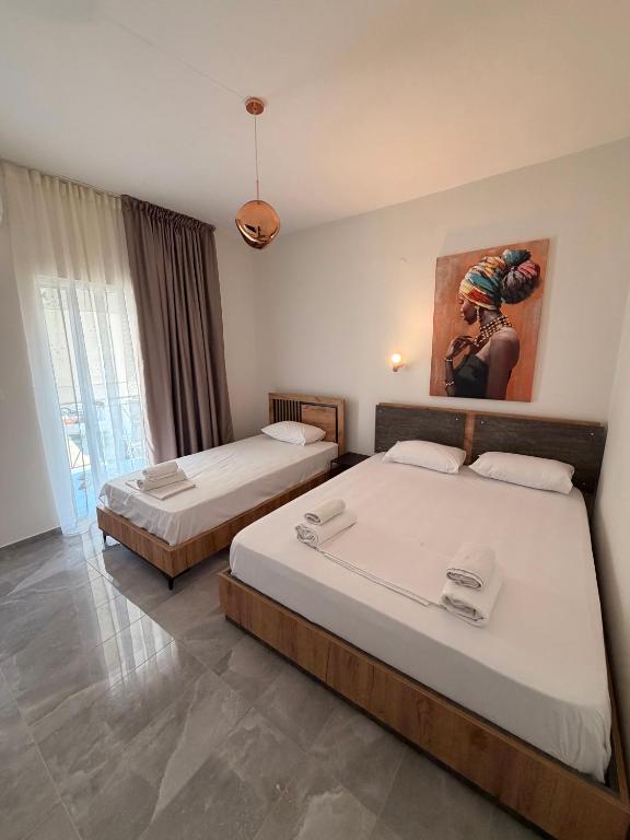 a bedroom with two beds and a painting on the wall at Rafael & Sofia Luxury Suites in Ammoudia