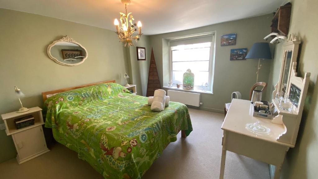 a bedroom with a bed and a table and a window at Market House 17th Century Boutique B&B in Wincanton