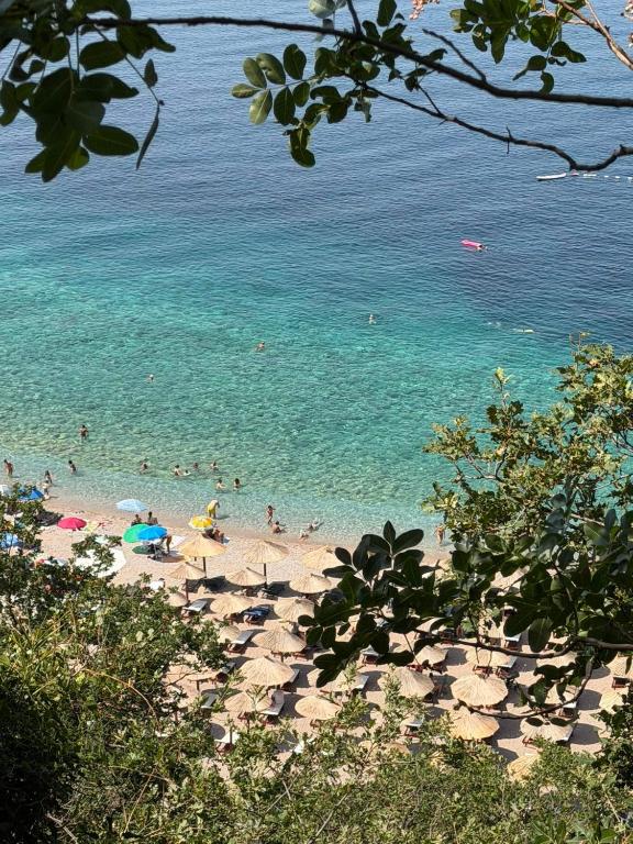 a beach with a bunch of people in the water at Vila Petra in Perazića Do