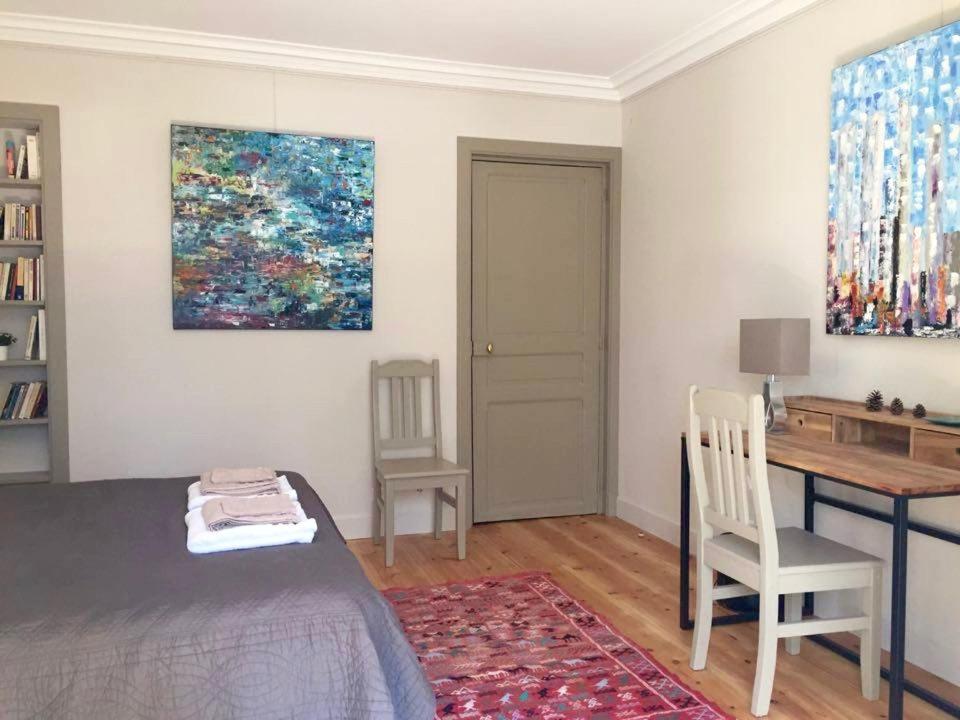a bedroom with a bed and a desk and a painting at 1 Square du Docteur Blanche - Paris 16 in Paris