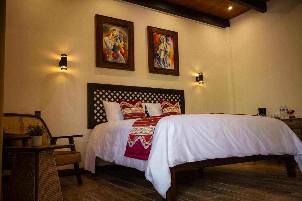 a bedroom with a bed and two pictures on the wall at Rincon del Buey Resort in Copán Ruinas