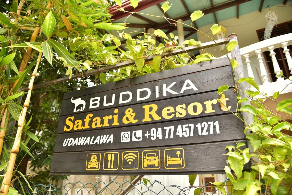 a sign for a safari and resort on a fence at Buddika Safari & Resort in Udawalawe