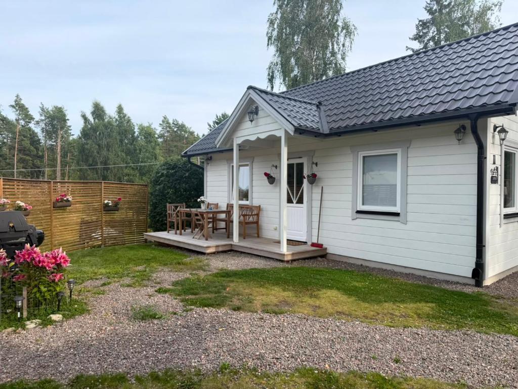 a white house with a picnic table in the yard at Charming cottage on Kvegero in Gnesta