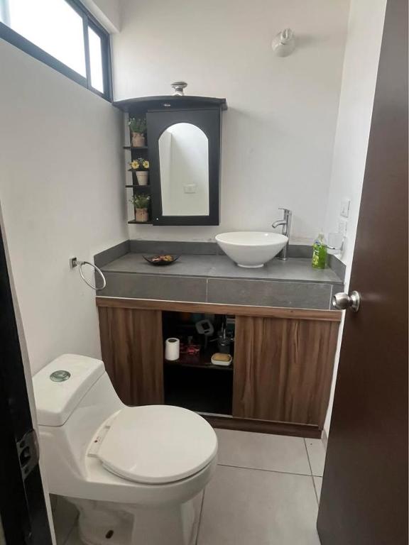 a bathroom with a white toilet and a sink at Alojamiento el Toro in Gómez