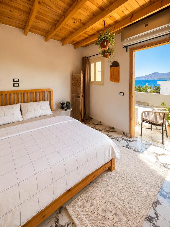 a bedroom with a bed and a large window at Bedro Rooftop Studio 2 Private Balcony Sea View 30 Sec to Sea in Dahab