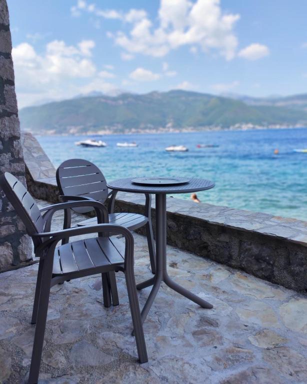a table and two chairs sitting next to the ocean at Marso in Krašići