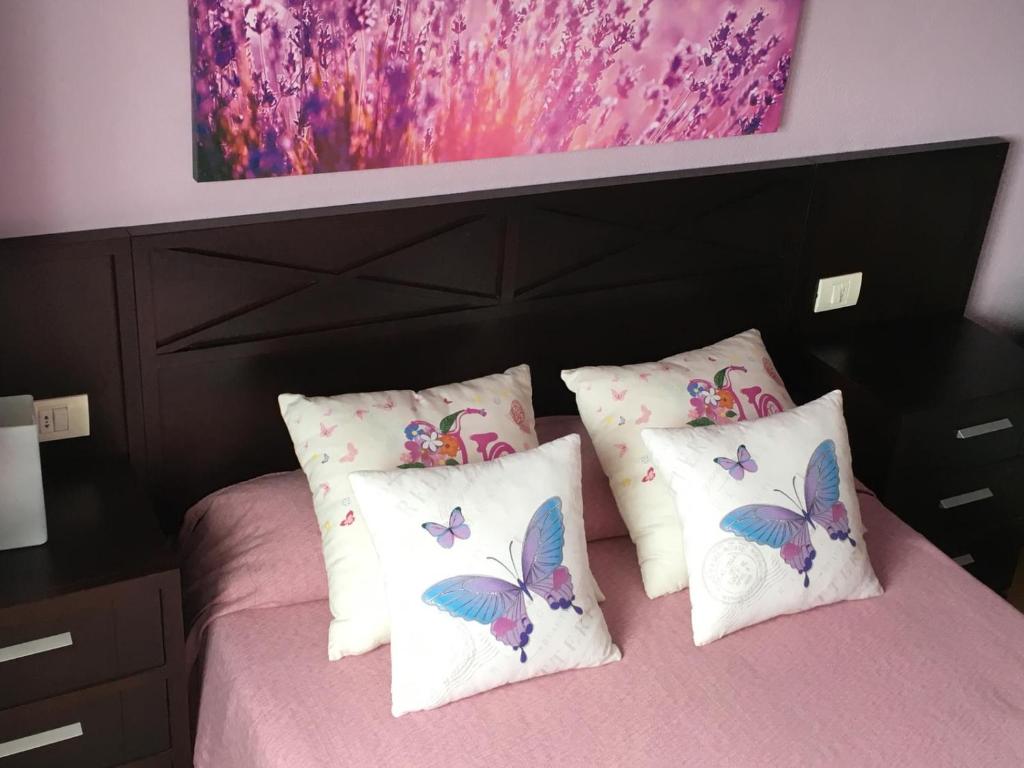 a bedroom with a bed with pillows and a painting at Casa el Durazno in Lodero