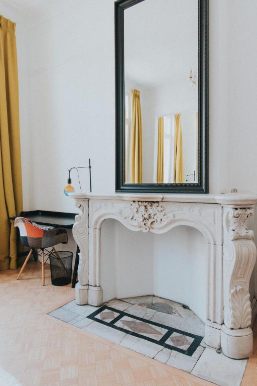 a mirror sitting on top of a white fireplace at Paulus41 in Antwerp
