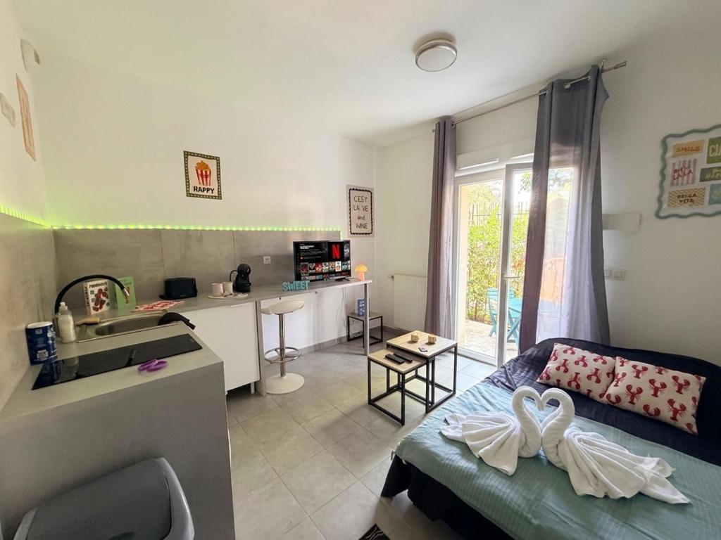 a room with a bed and a kitchen with a sink at Côté green in Juvignac