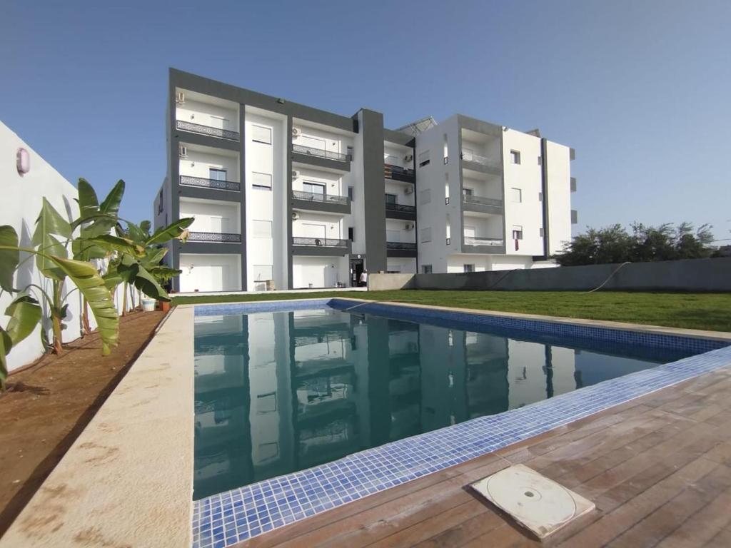 a swimming pool in front of a building at Horizon yasmine in Yasmine