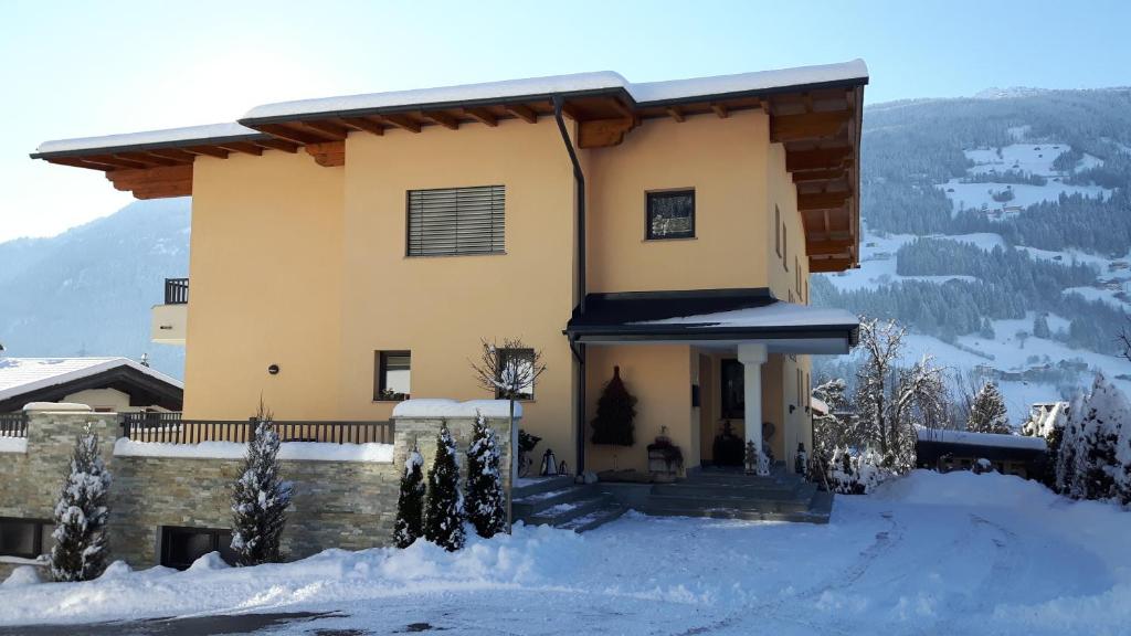ein Haus im Schnee mit Bergen im Hintergrund in der Unterkunft Appartement Anna-Maria in Stumm
