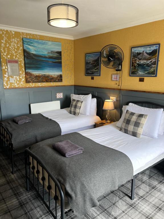 two beds in a hotel room with two bedsvisor at BELLFIELD HOUSE in Broadford