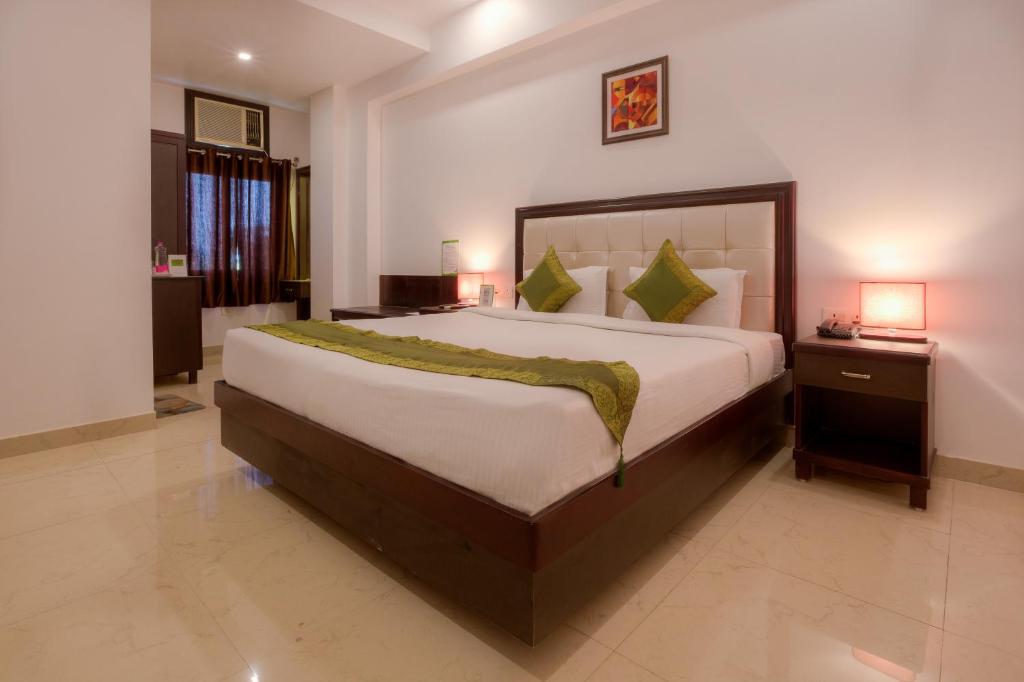 um quarto com uma cama grande num quarto em Treebo Trend Shivam Inn near Singapore Mall em Lucknow