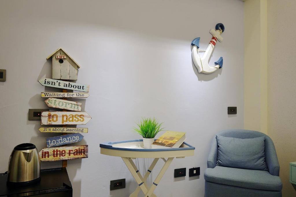 a room with a table and a blue chair and a table and a bird house at 品斯行旅 台中逢甲館 Pins INN in Taichung