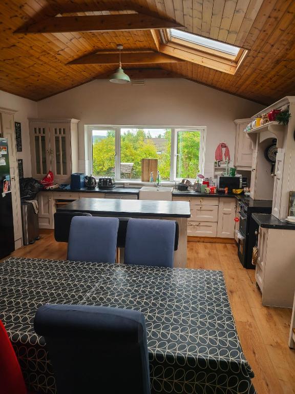 a kitchen with a table and blue chairs in it at Iona in Blessington