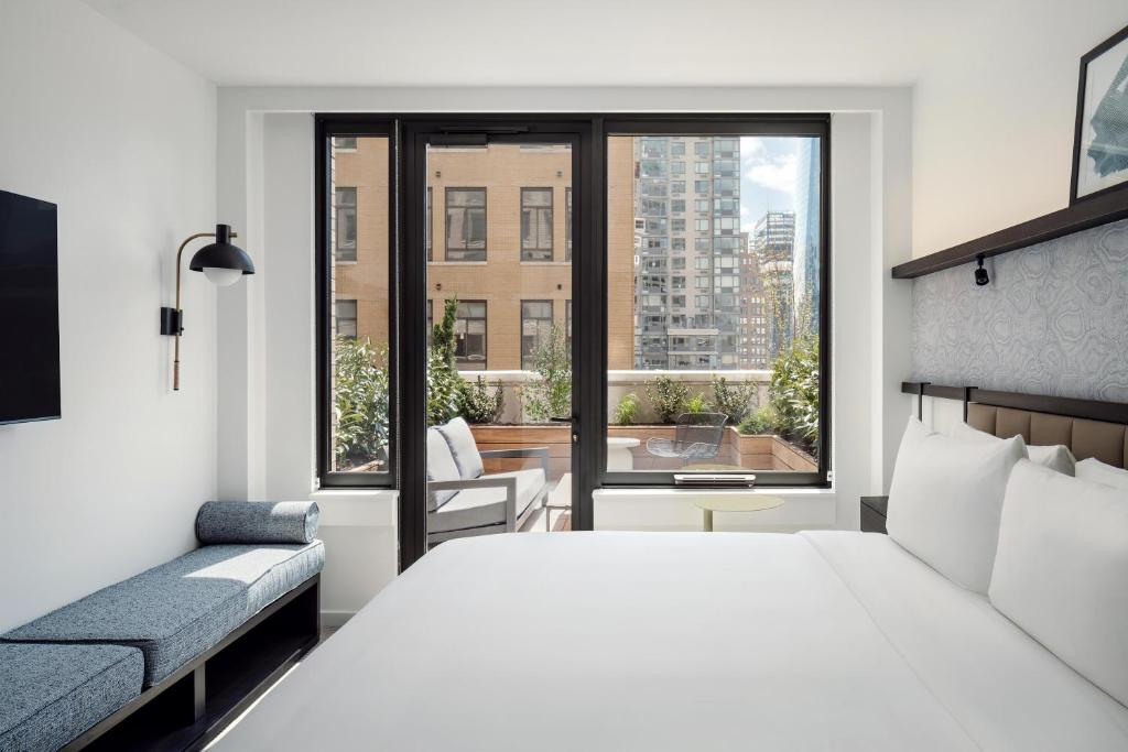 a bedroom with a large white bed and a window at Arlo Midtown in New York