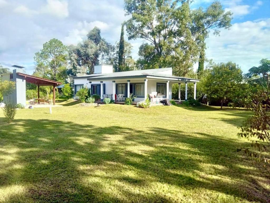a small white house with a large yard at El Prado Chico, Casa de Campo in Salta