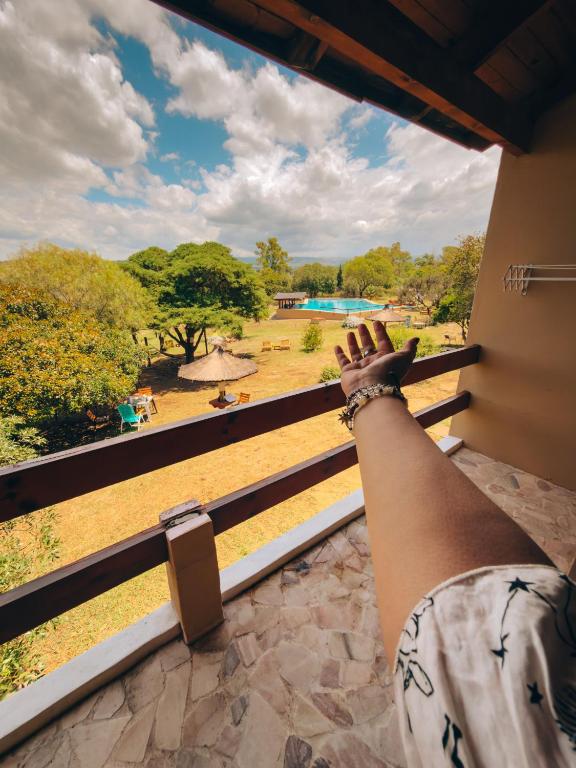 a person standing on a balcony looking out at a park at Apart hotel Agua Dorada in Cavalango