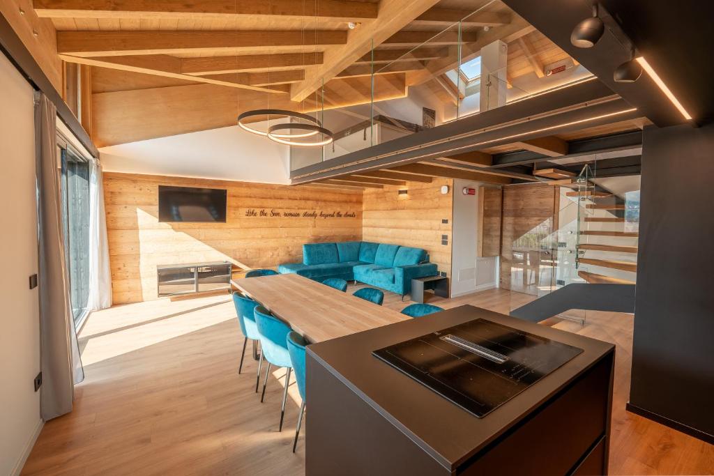 a kitchen and dining room with a table and blue chairs at Echo - Private Spa Apartments in Ponte di Legno