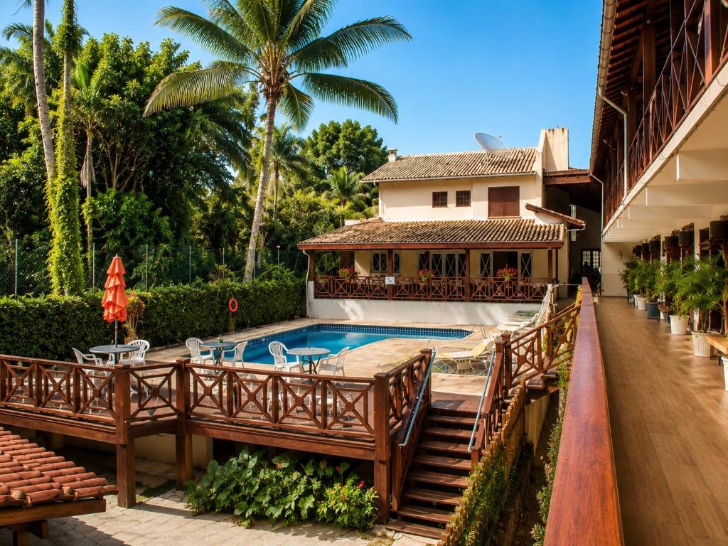 a resort with a swimming pool and a house at Hotel Canto do Rio Maresias in Maresias