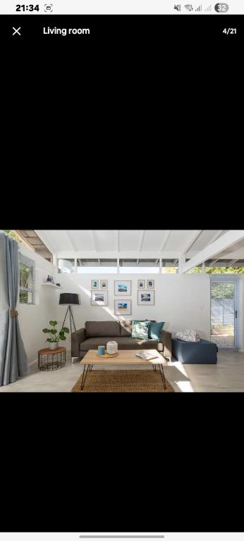 a living room with a couch and a table at Kai Cottage in Bergvliet