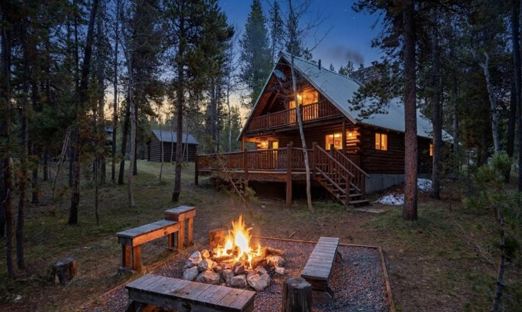 a fire pit in front of a log cabin at The Hailey Cabin in Island Park