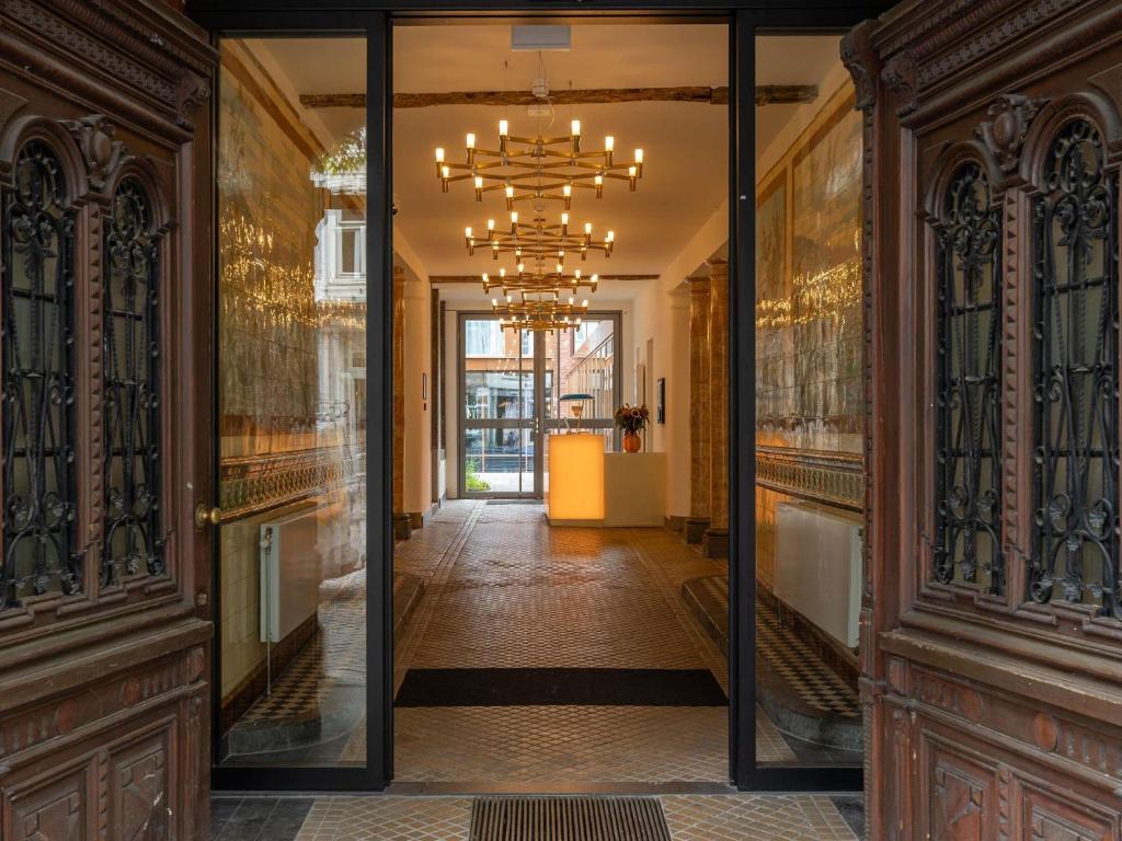 a hallway with a mirror and a chandelier at Hotel Maison Maastricht Centrum - Handwritten Collection in Maastricht