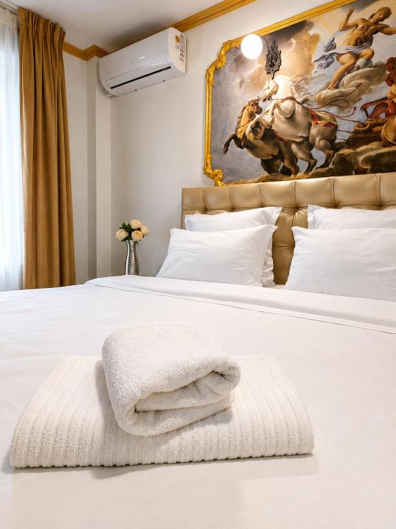 a white bed with a pile of towels on it at Nobilis Boutique Foisor in Bucharest