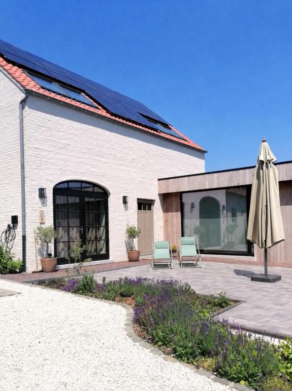 a patio with two chairs and an umbrella at Le Repos in Brakel