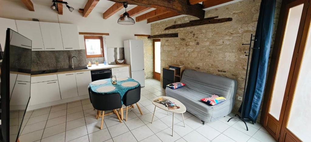 a kitchen with a couch and a table in a kitchen at Gîte de l'Aiguillier in Castelnau-de-Montratier