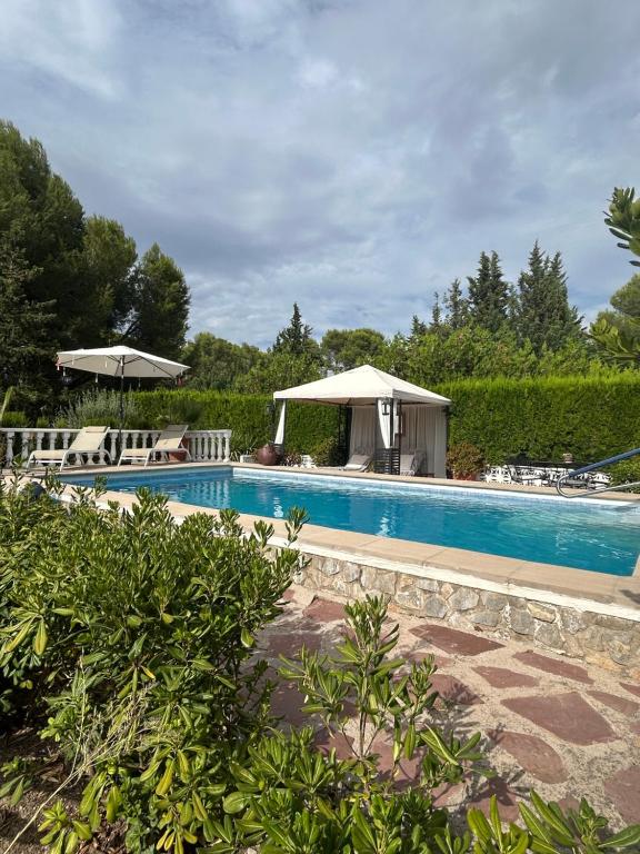 a swimming pool with chairs and a gazebo at Finca Malata in Turís