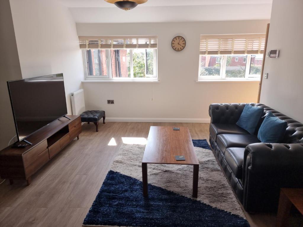 a living room with a couch and a coffee table at Exeter Executive Apartments in Pinhoe
