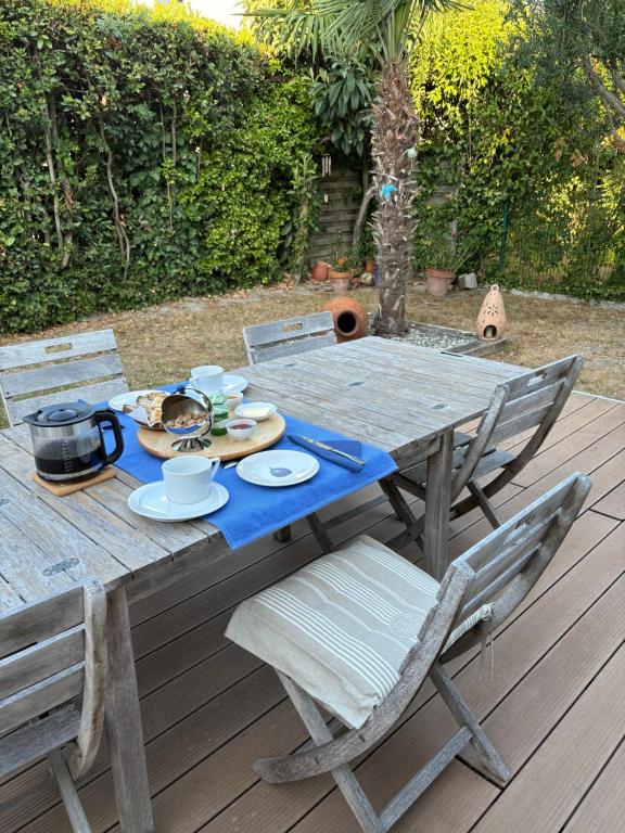 a wooden table and chairs on a wooden deck at Chambre d'hôtes les Galets Bleus in La Rochelle
