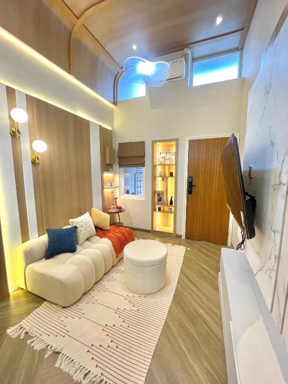 a living room with a white couch and a tv at Willow House in Padalarang