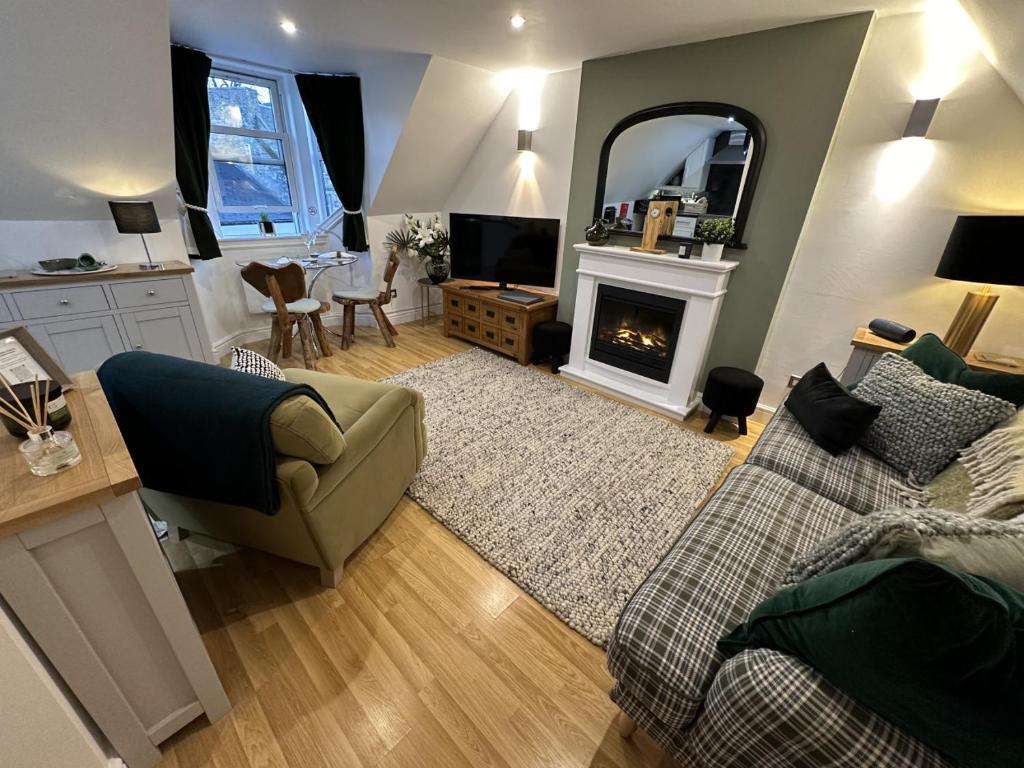 a living room with a couch and a fireplace at The Canongate Coorie in Jedburgh